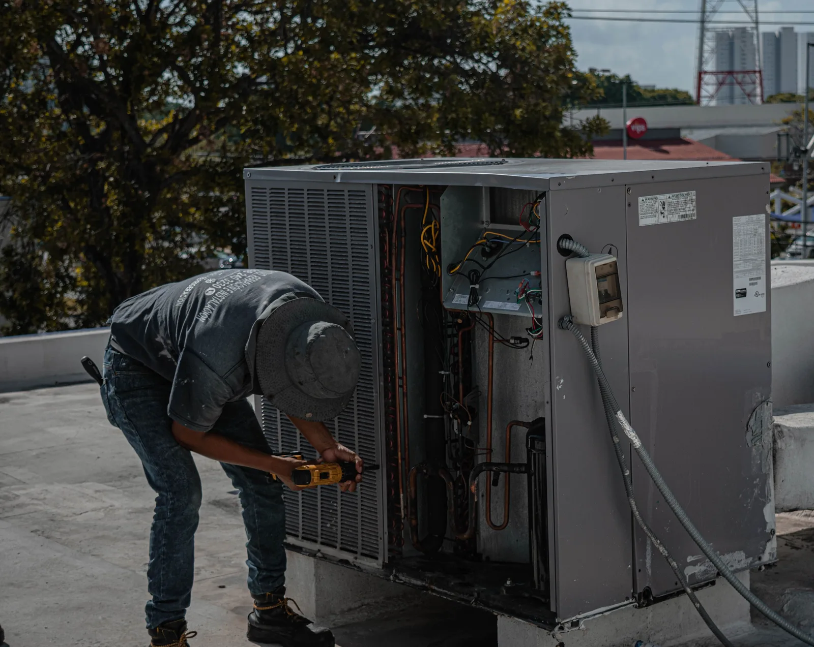 HVAC technician opening an air conditioning unit to inspect the components before recommending a replacement