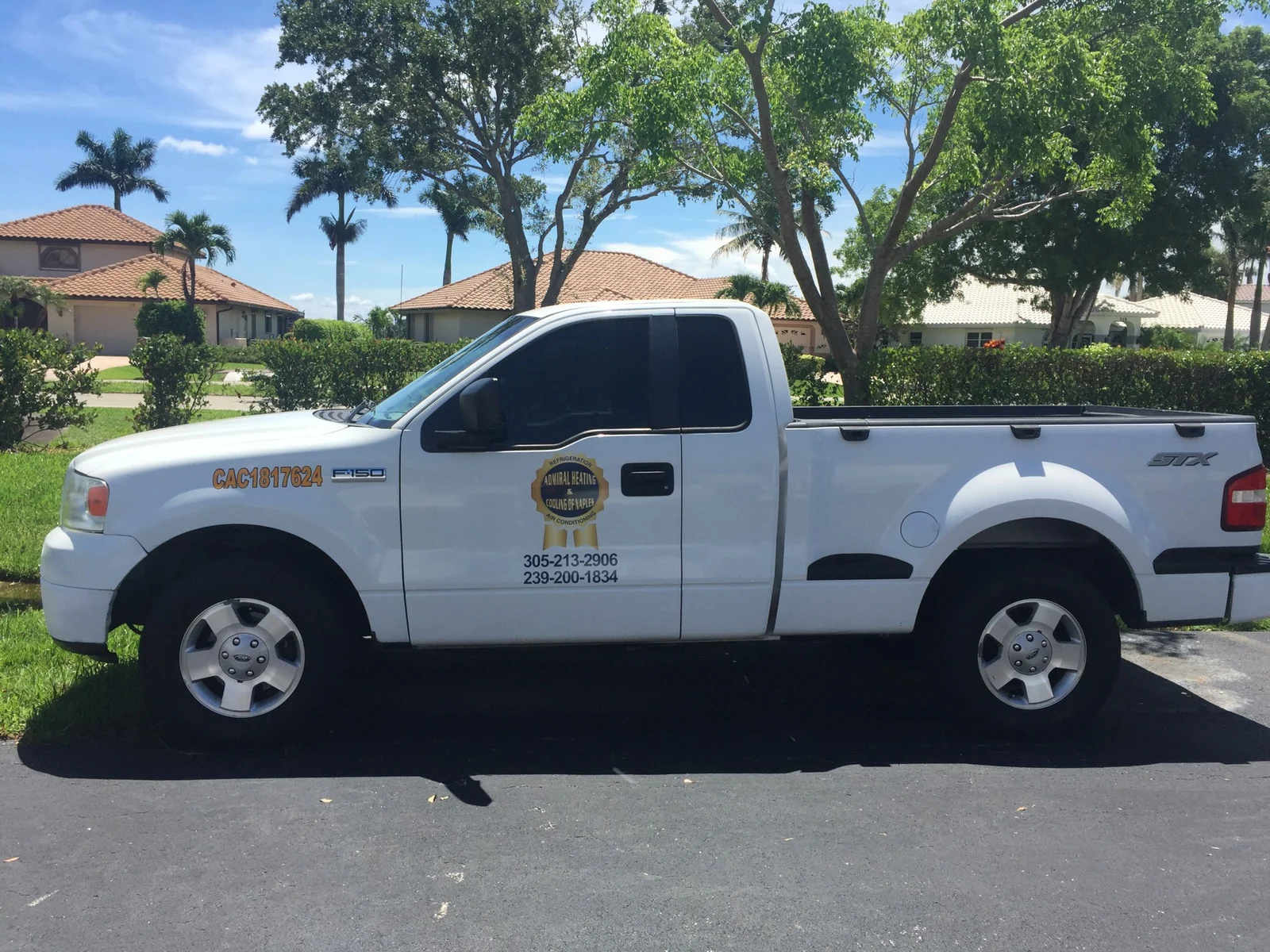 Admiral Heating and Cooling of Naples service truck with license CAC1817624 on the door in a Naples neighborhood